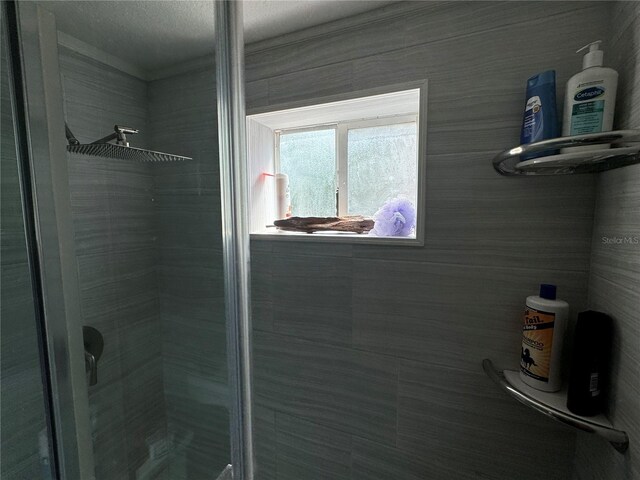 bathroom with a shower with door