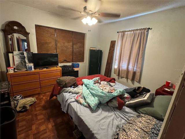 bedroom featuring ceiling fan and dark parquet flooring