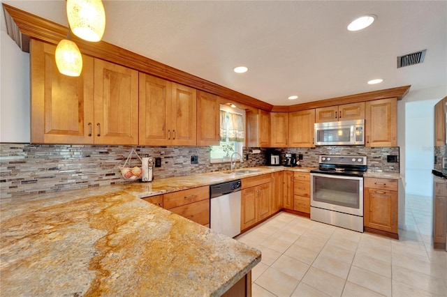 kitchen with sink, hanging light fixtures, light tile patterned floors, light stone counters, and stainless steel appliances