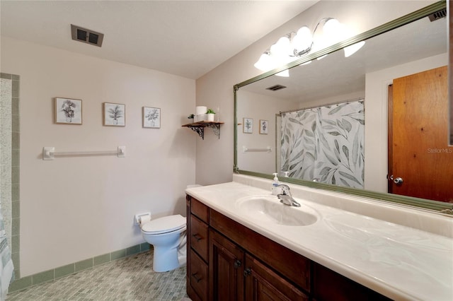 bathroom with a shower with curtain, vanity, toilet, and tile patterned flooring