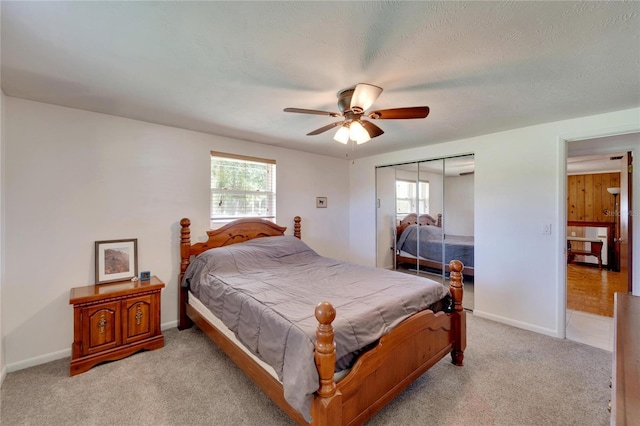 bedroom featuring multiple windows, light carpet, ceiling fan, and a closet