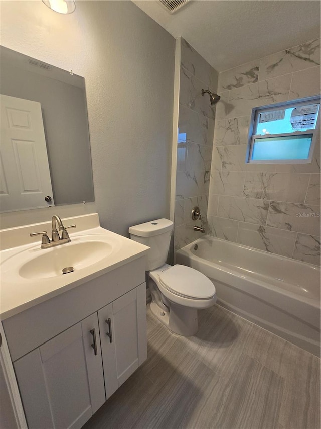 full bathroom with tiled shower / bath combo, vanity, and toilet