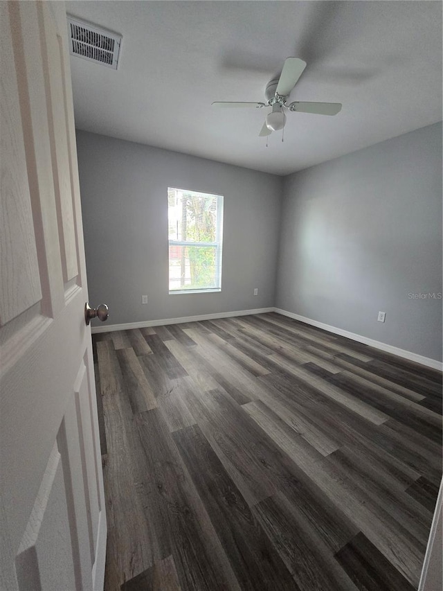 empty room with dark wood-type flooring and ceiling fan