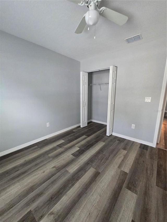 unfurnished bedroom featuring ceiling fan, dark hardwood / wood-style floors, and a closet