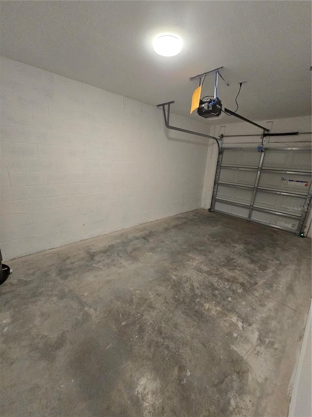 garage with concrete block wall and a garage door opener