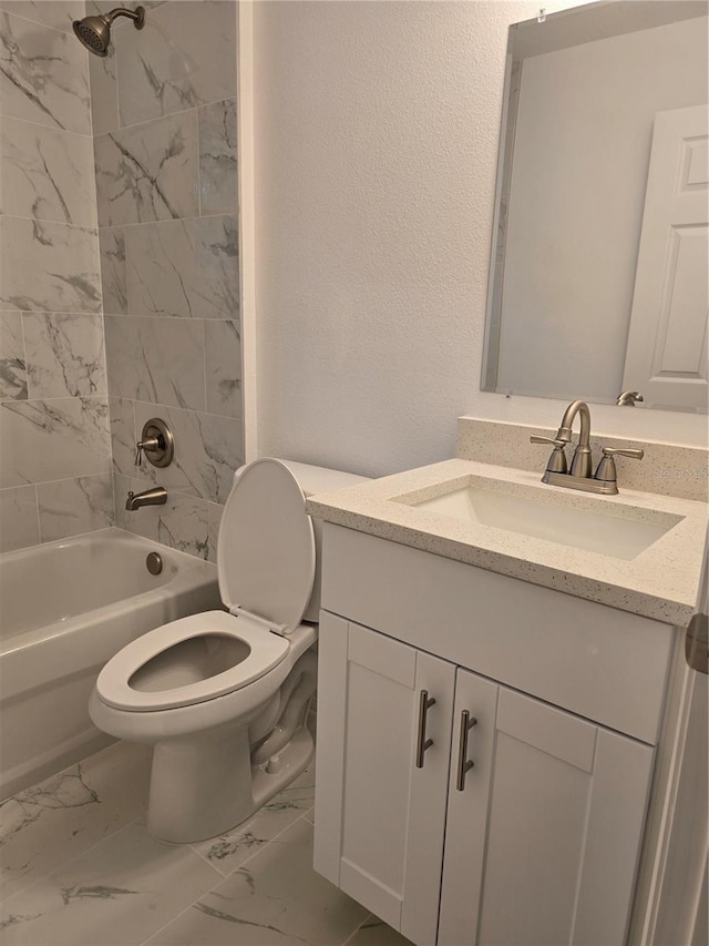 bathroom featuring vanity, marble finish floor, washtub / shower combination, and toilet