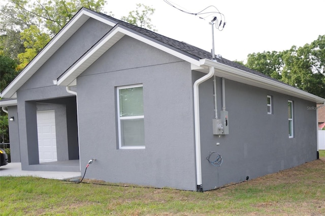 view of side of home featuring a lawn and stucco siding