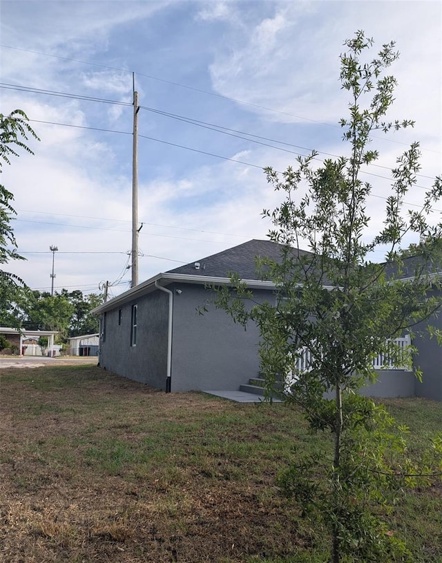 view of home's exterior featuring stucco siding and a yard