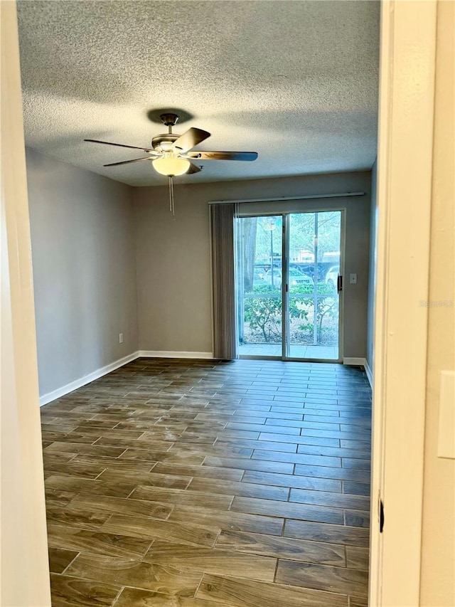 empty room with dark wood-type flooring, a textured ceiling, and ceiling fan