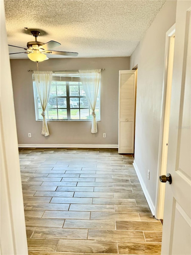 unfurnished room featuring a textured ceiling and ceiling fan