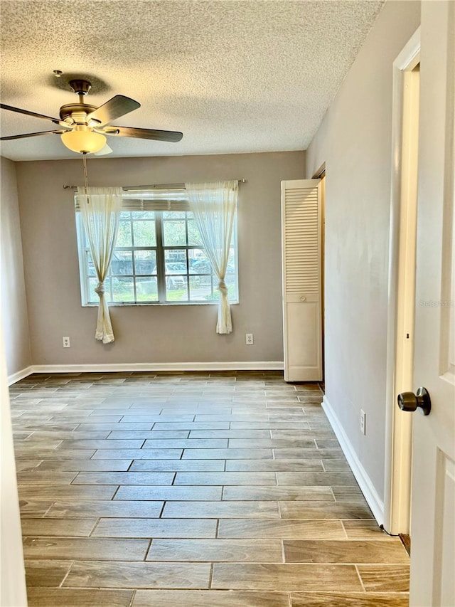 empty room featuring a textured ceiling and ceiling fan