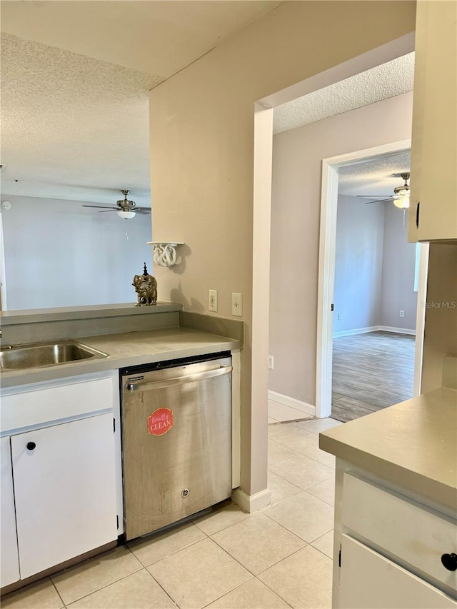 kitchen with ceiling fan, stainless steel dishwasher, a textured ceiling, and white cabinets