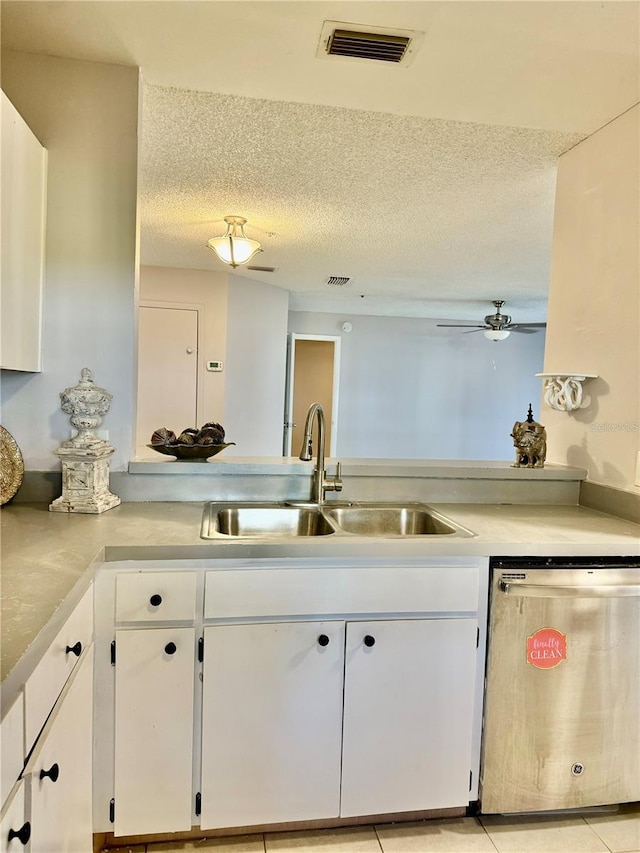 kitchen featuring dishwasher, sink, white cabinets, ceiling fan, and a textured ceiling