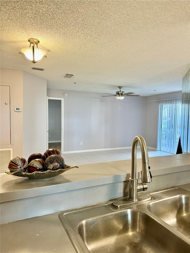 interior details featuring sink, a textured ceiling, and ceiling fan