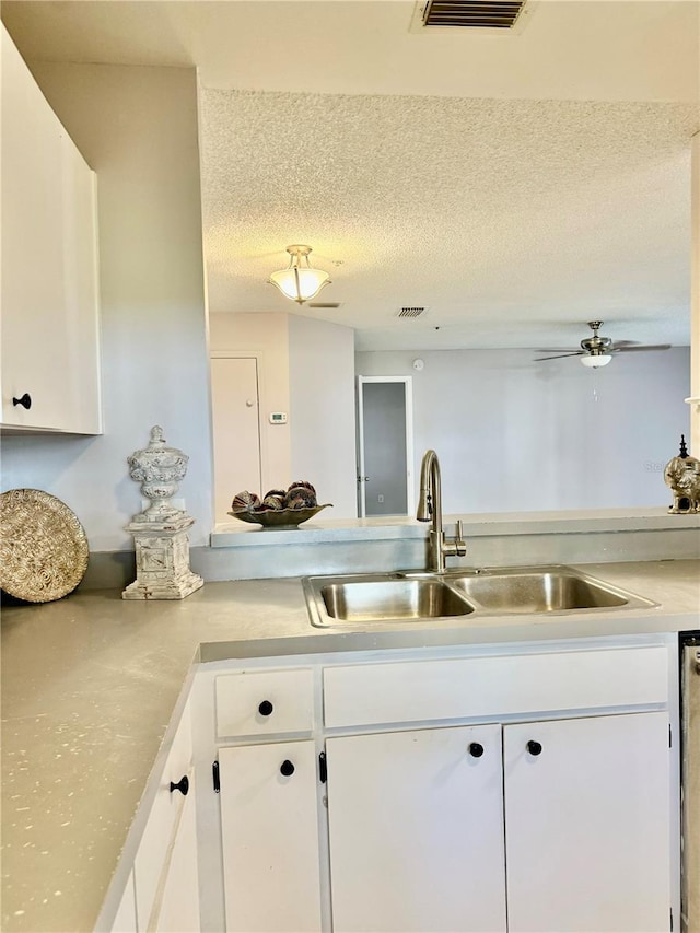 kitchen featuring white cabinetry, sink, a textured ceiling, and ceiling fan