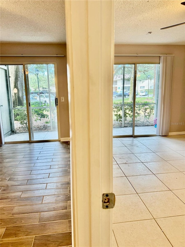 entryway featuring ceiling fan, wood-type flooring, and a textured ceiling