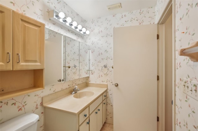 bathroom featuring toilet and vanity