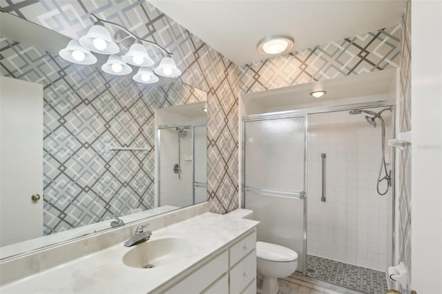 bathroom featuring toilet, a shower with door, and vanity