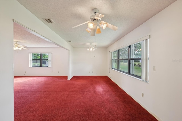 carpeted empty room featuring a textured ceiling