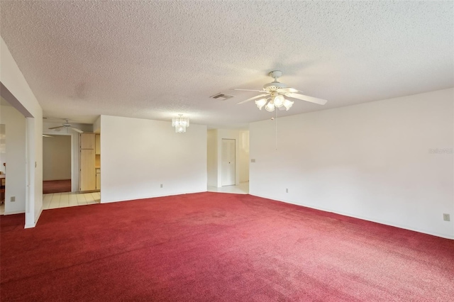 carpeted spare room with a textured ceiling and ceiling fan with notable chandelier