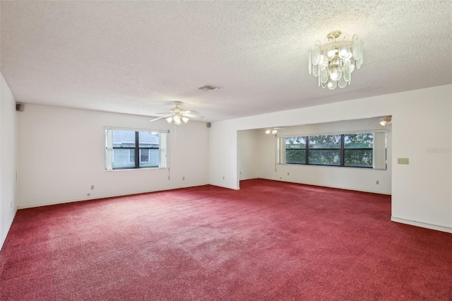 carpeted empty room with ceiling fan with notable chandelier and a textured ceiling