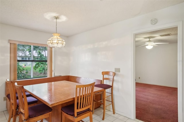 dining room with a textured ceiling, ceiling fan, and light tile patterned floors