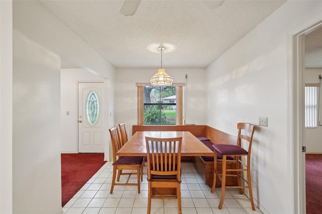 dining room featuring a textured ceiling and light carpet