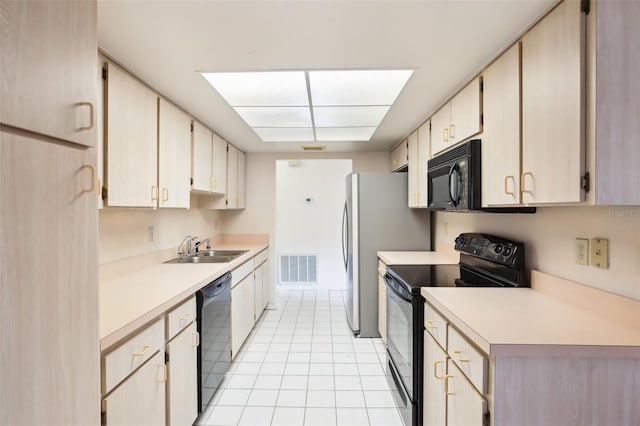 kitchen with black appliances, sink, and light tile patterned floors