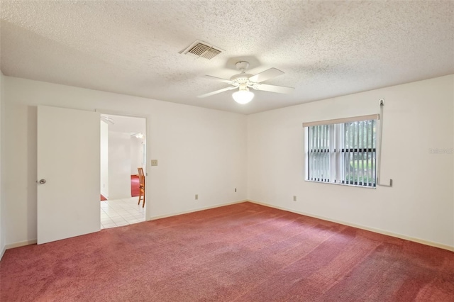 spare room featuring light colored carpet, ceiling fan, and a textured ceiling