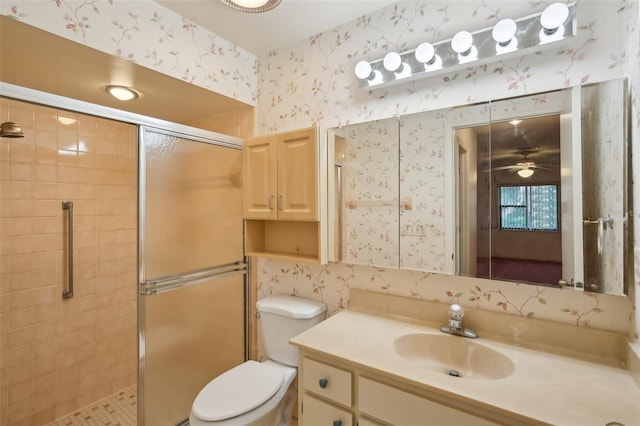 bathroom with toilet, a shower with door, vanity, and ceiling fan