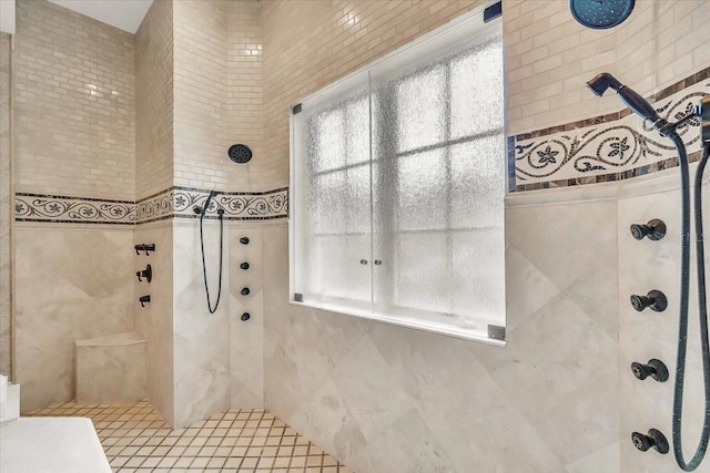 bathroom featuring a tile shower and a wealth of natural light