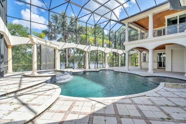 view of pool with glass enclosure, an in ground hot tub, pool water feature, and a patio