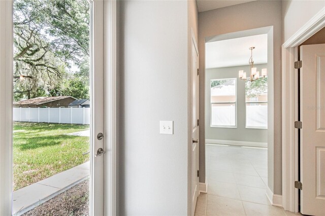 entryway with a notable chandelier and light tile patterned floors