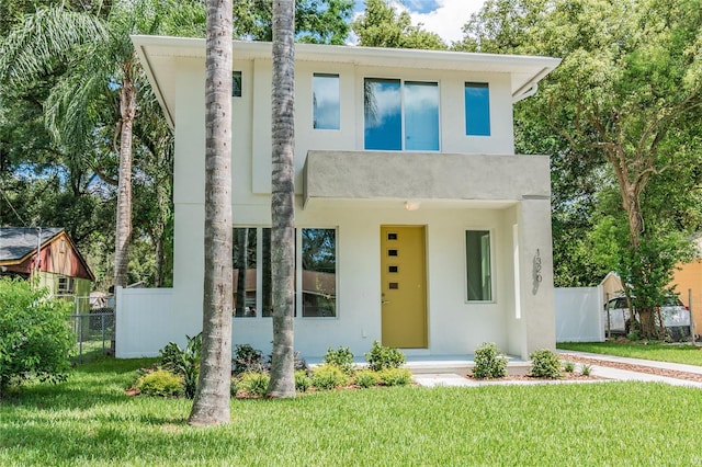 modern home with a balcony and a front lawn