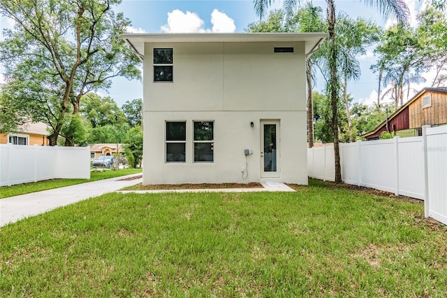 back of house with a lawn