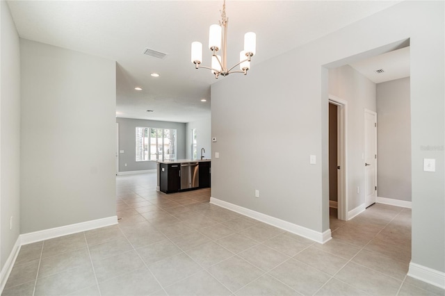 tiled empty room with a notable chandelier and sink