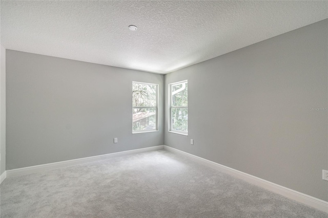 carpeted spare room featuring a textured ceiling