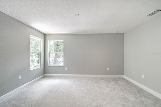 carpeted empty room with a textured ceiling