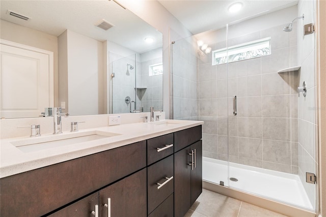 bathroom with an enclosed shower, vanity, and tile patterned floors