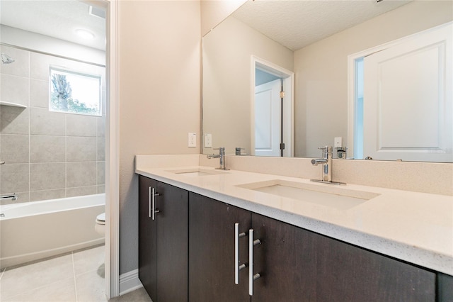 full bathroom with toilet, a textured ceiling, tile patterned floors, tiled shower / bath combo, and vanity