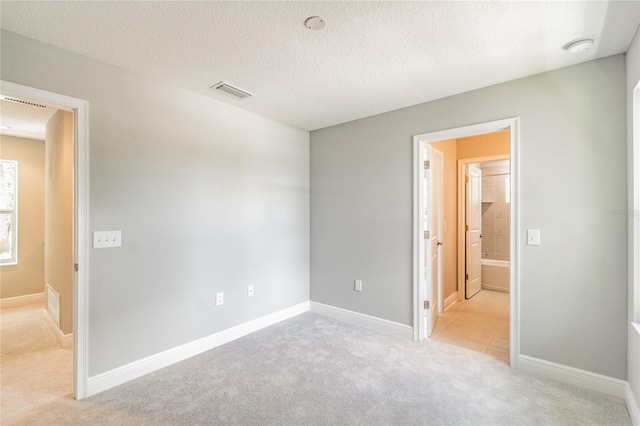 interior space with light colored carpet and a textured ceiling