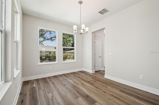 2909 W Spruce St, Tampa, FL 33607 - unfurnished room with a chandelier and wood finished floors