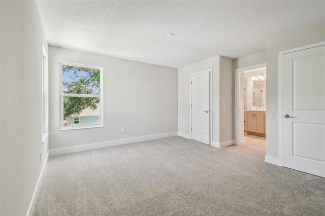 2909 W Spruce St, Tampa, FL 33607 - unfurnished bedroom featuring light carpet, a textured ceiling, and ensuite bath