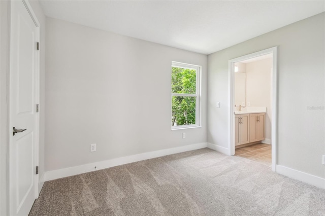 2909 W Spruce St, Tampa, FL 33607 - unfurnished bedroom with light colored carpet and connected bathroom