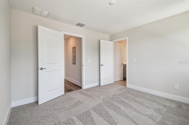 2909 W Spruce St, Tampa, FL 33607 - unfurnished bedroom featuring carpet floors, a textured ceiling, and electric panel