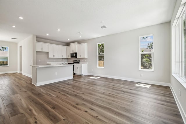 2909 W Spruce St, Tampa, FL 33607 - kitchen with open floor plan, stainless steel microwave, healthy amount of natural light, wood finished floors, and recessed lighting