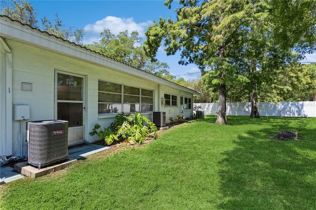 view of yard with central AC and fence