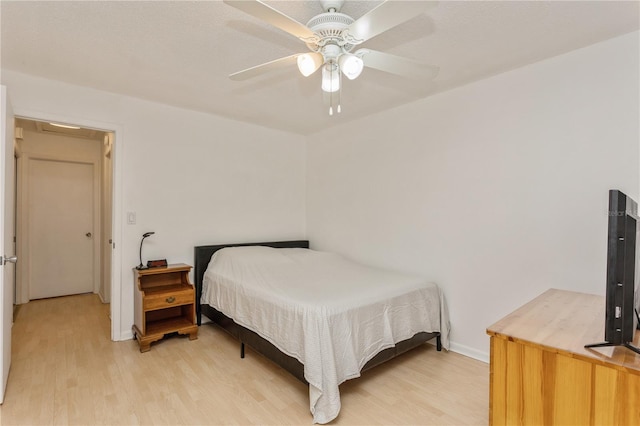 bedroom with a ceiling fan, light wood-style flooring, and baseboards