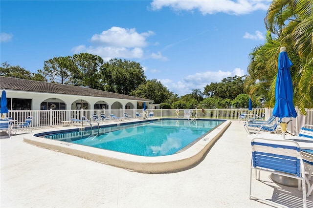 pool with a patio and fence