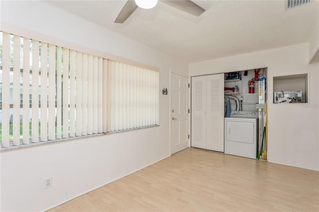 interior space with washer / clothes dryer, visible vents, a textured ceiling, wood finished floors, and laundry area